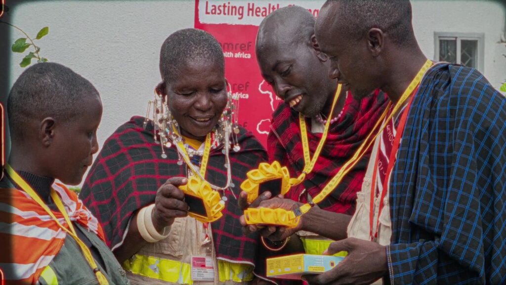 People examine the yellow Little Sun solar lamp together and smile