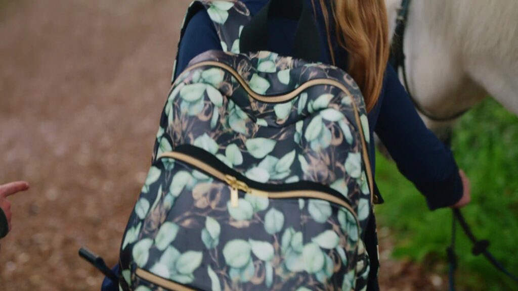 Girl carries the self-sewn backpack with a leaf pattern next to the pony
