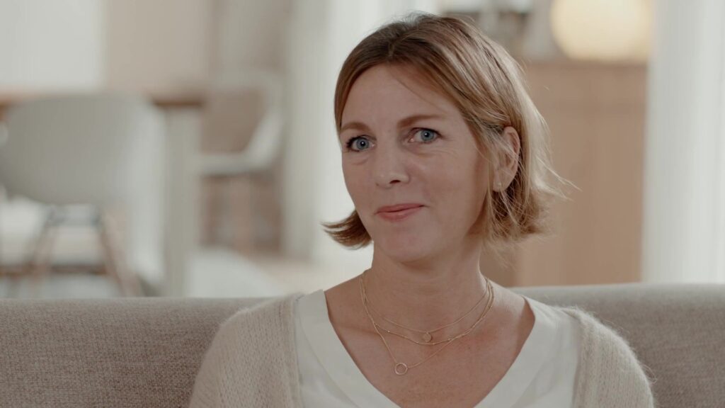 Warm portrait of Mathilda's smiling mother in the bright living room