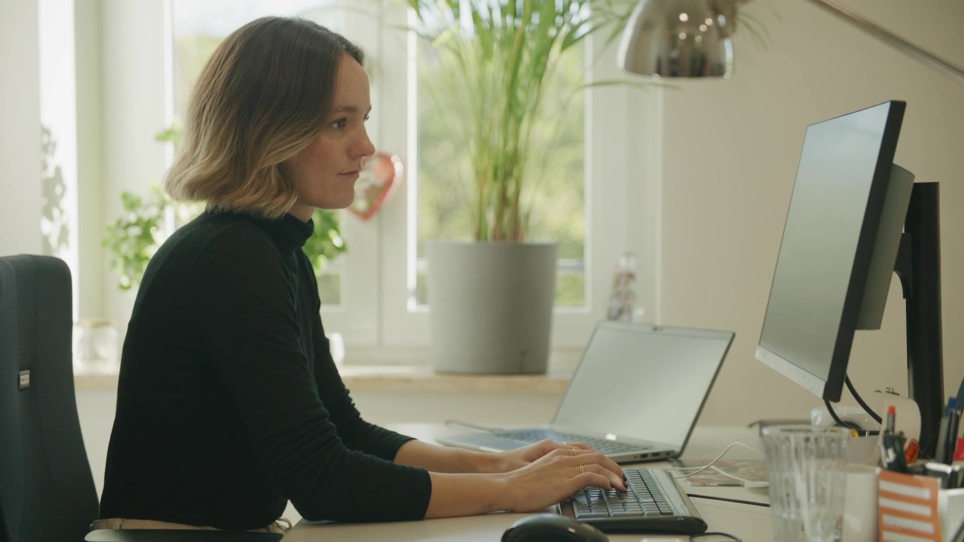 Employee works with focus at the screen in a bright office