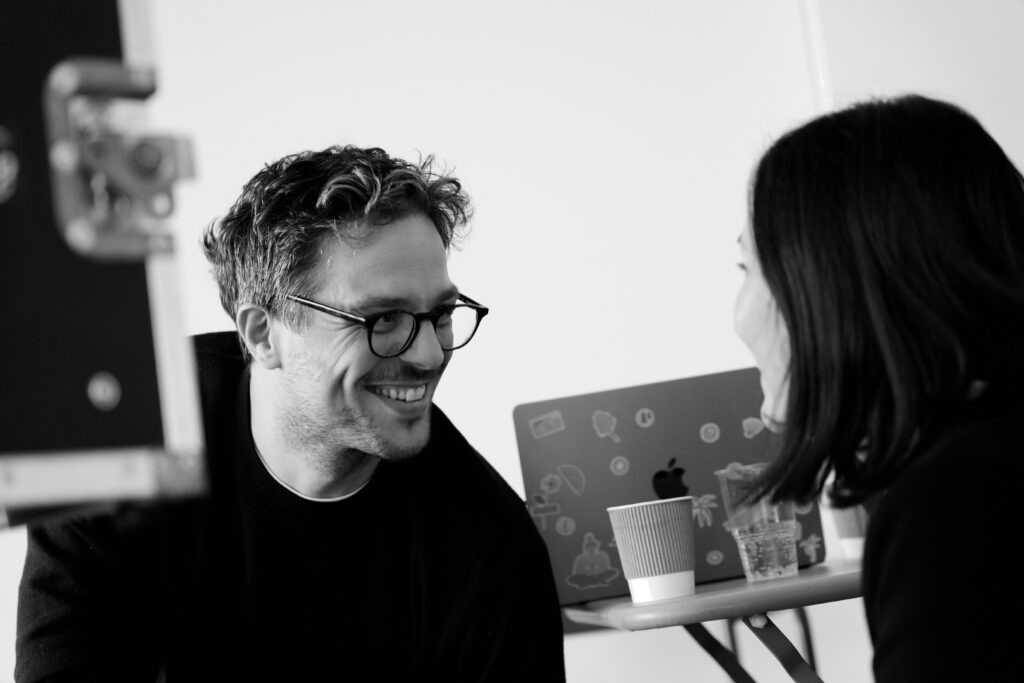 Entspanntes Gespräch am Set: ein Protagonist lacht in der Drehpause
