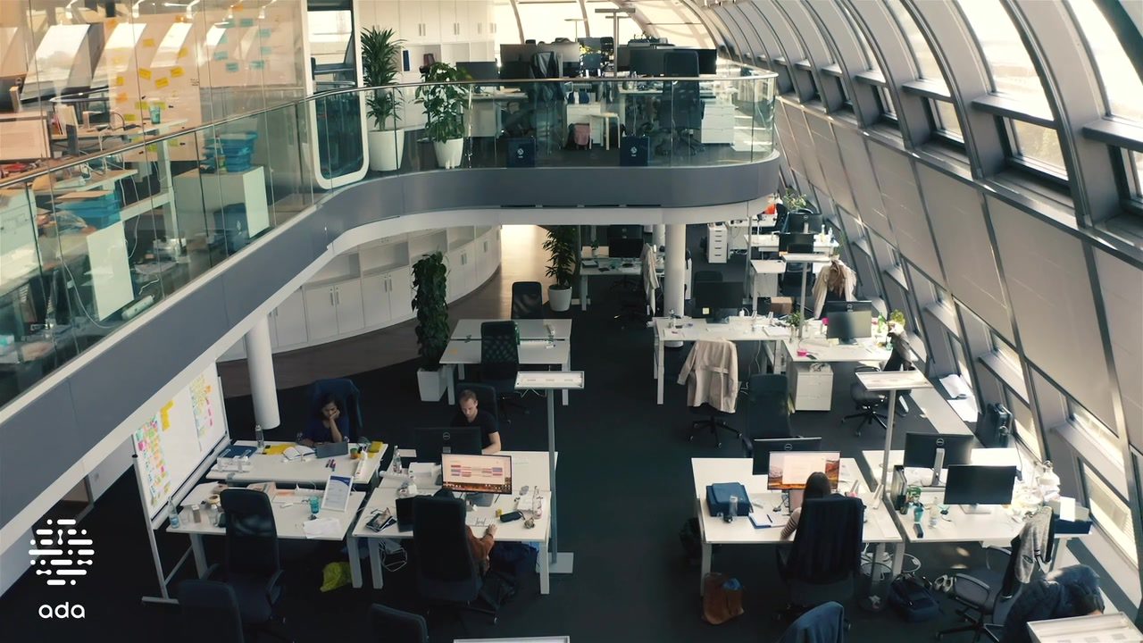 Light-filled open-plan office at Ada Health with a curved gallery