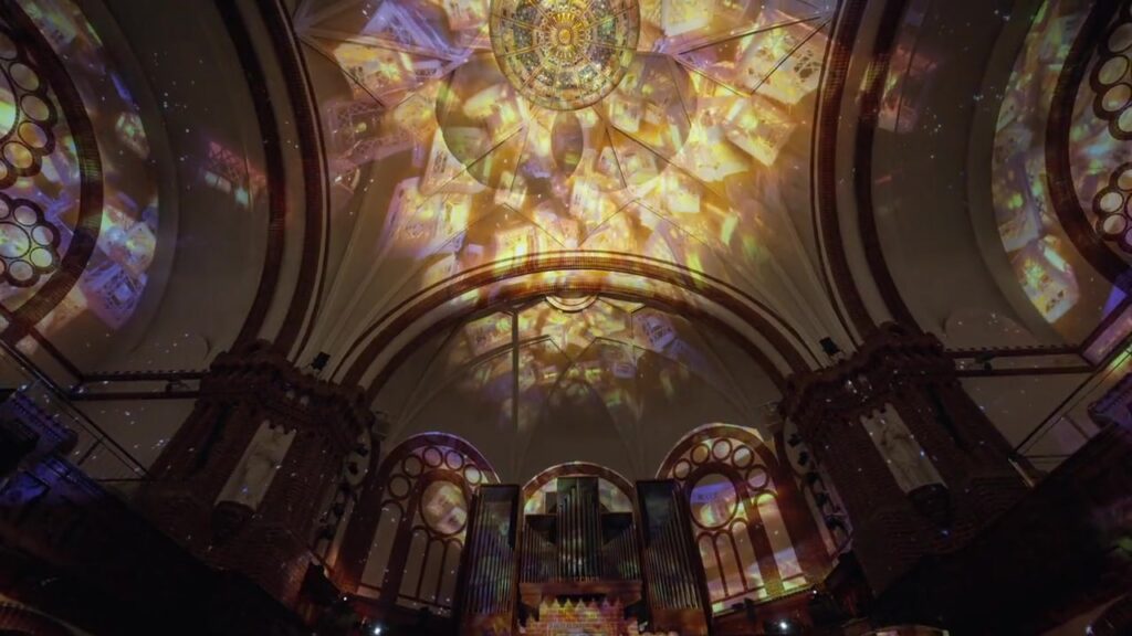 Goldene Projektionen erleuchten das Kirchengewölbe über der Orgel