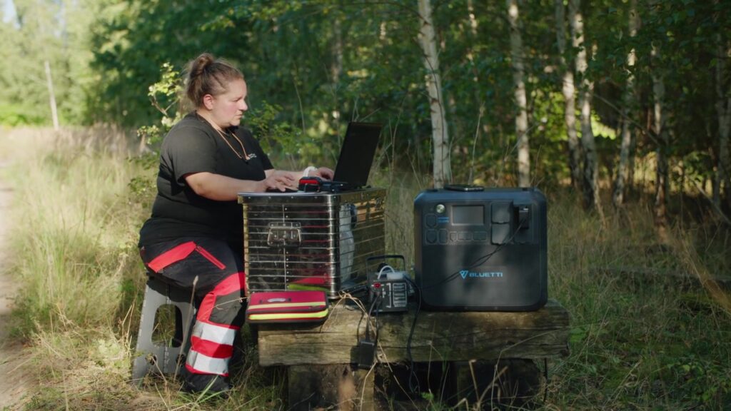 Hundeführerin arbeitet am Laptop, versorgt von einer Bluetti Powerstation
