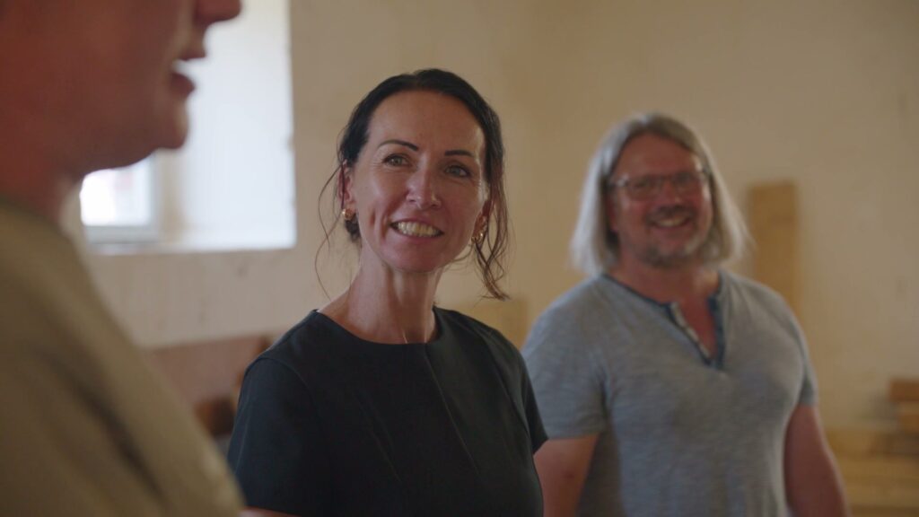 Anja Friedrich und Michael Köste lachen gemeinsam in der Werkstatt auf dem Hof Bockelwitz