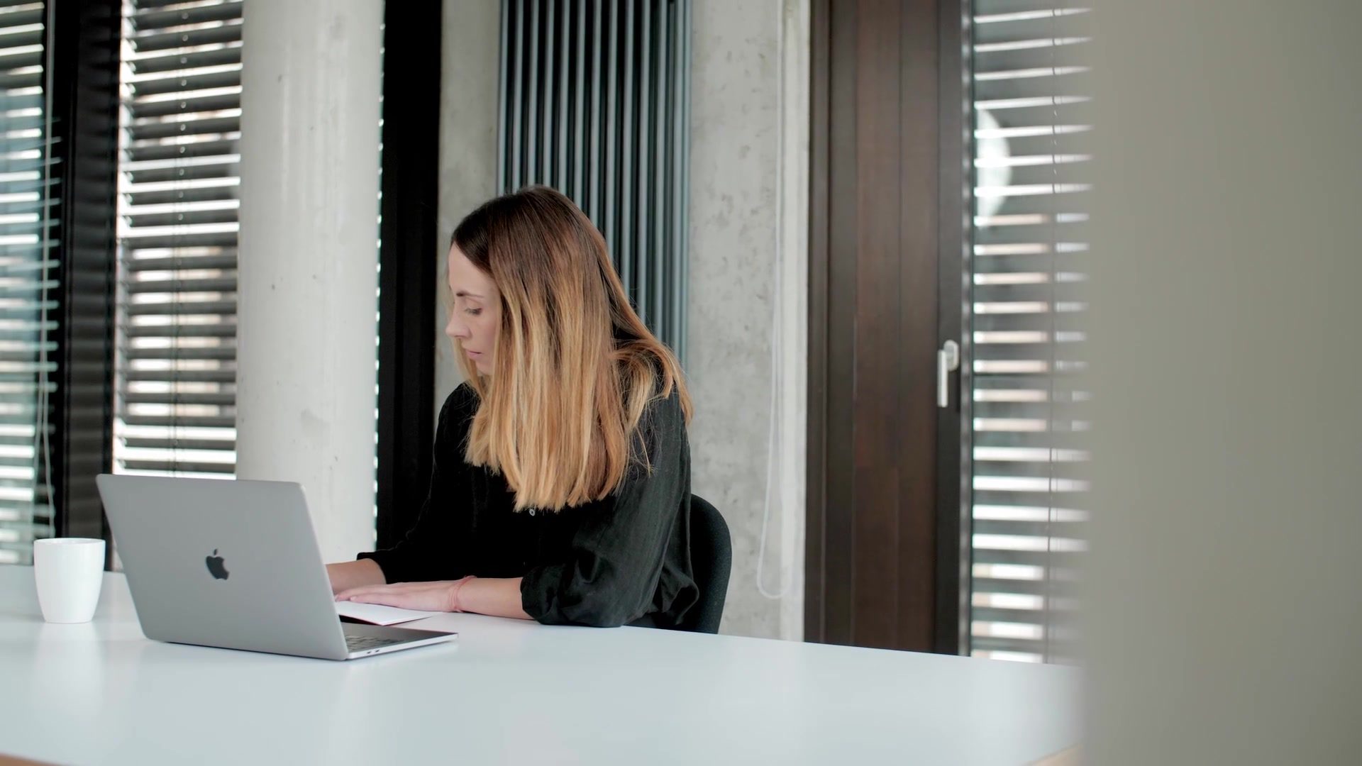UX designer working on a laptop in init AG's modern office