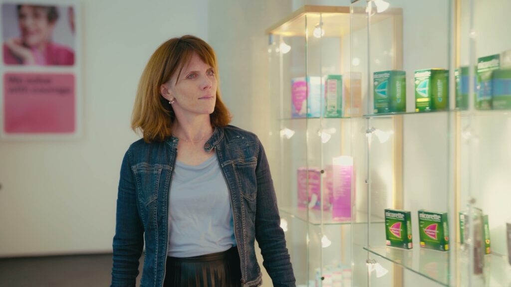 Elke betrachtet eine beleuchtete Vitrine mit Kenvue-Produkten im Büro in Neuss.
