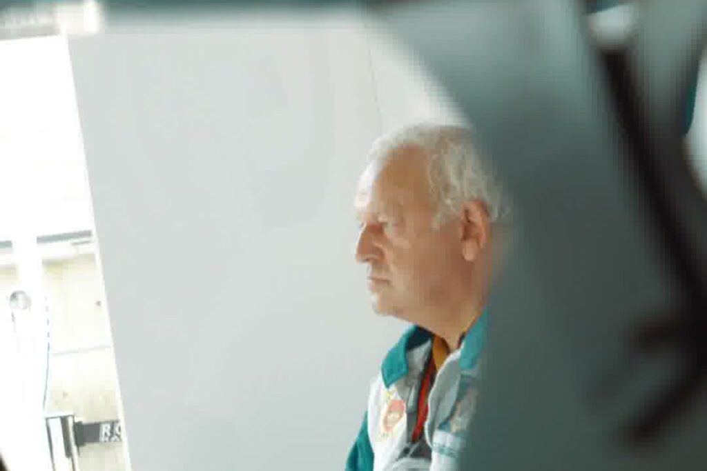 A motorsport veteran watches the action from the pit box.