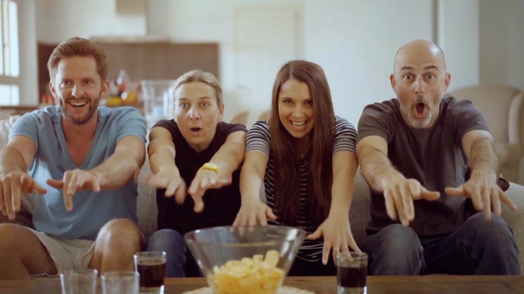 Vier Fans fiebern auf dem Sofa beim WM-Spiel mit