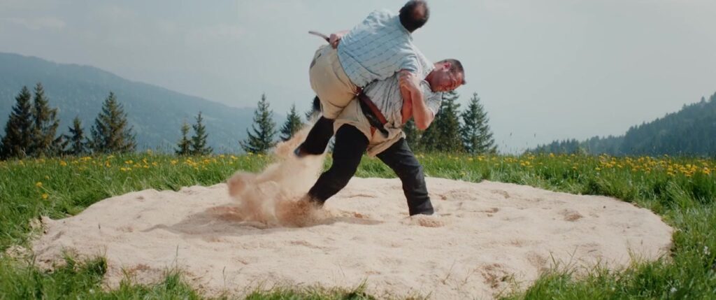 Zwei Schwinger kämpfen im Sägemehlring vor Bergpanorama