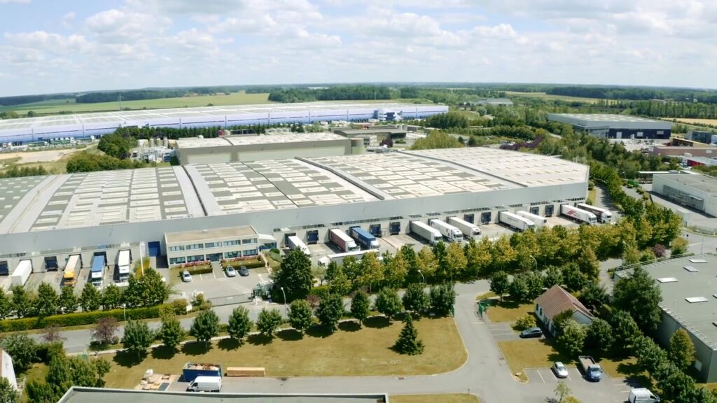 Luftaufnahme des großen Logistikzentrums mit Laderampen und Lkw