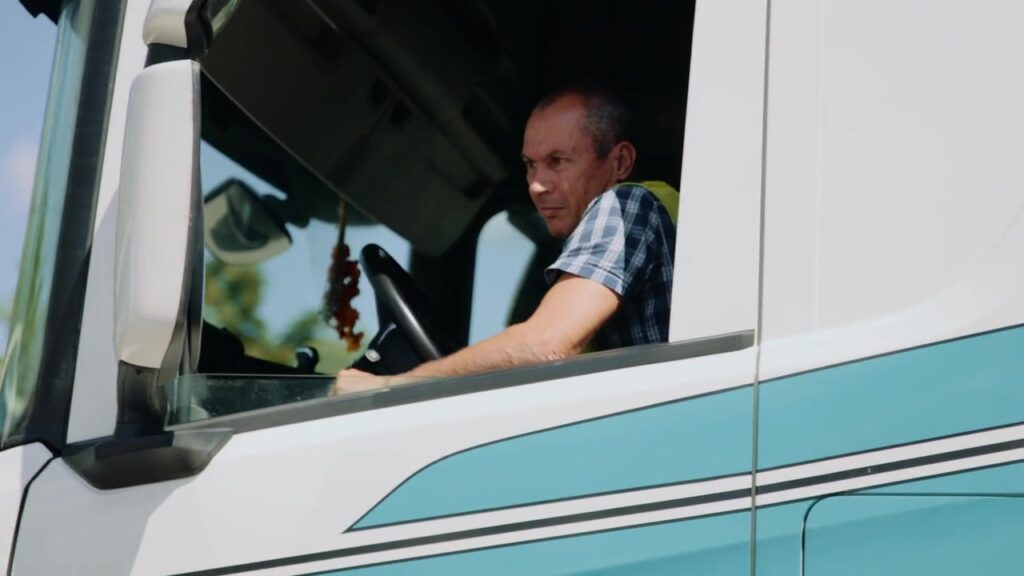 Lkw-Fahrer blickt konzentriert aus dem Fenster seiner Zugmaschine