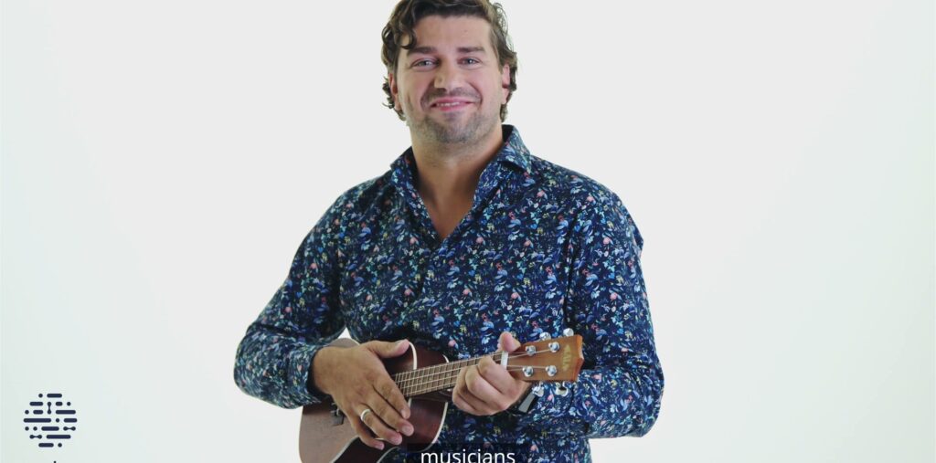 Ein Ada-Mitarbeiter mit Ukulele im weißen Studio, Recruitingfilm von ROCC Film