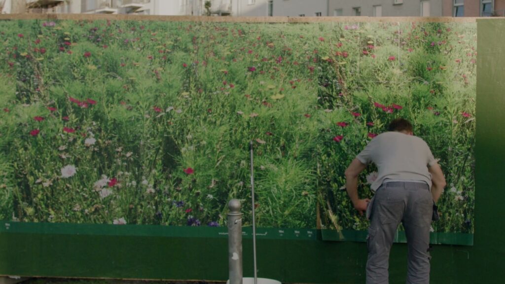 A "Flower Meadow" poster is being put up: the zero-budget cultural poster campaign for Berlin